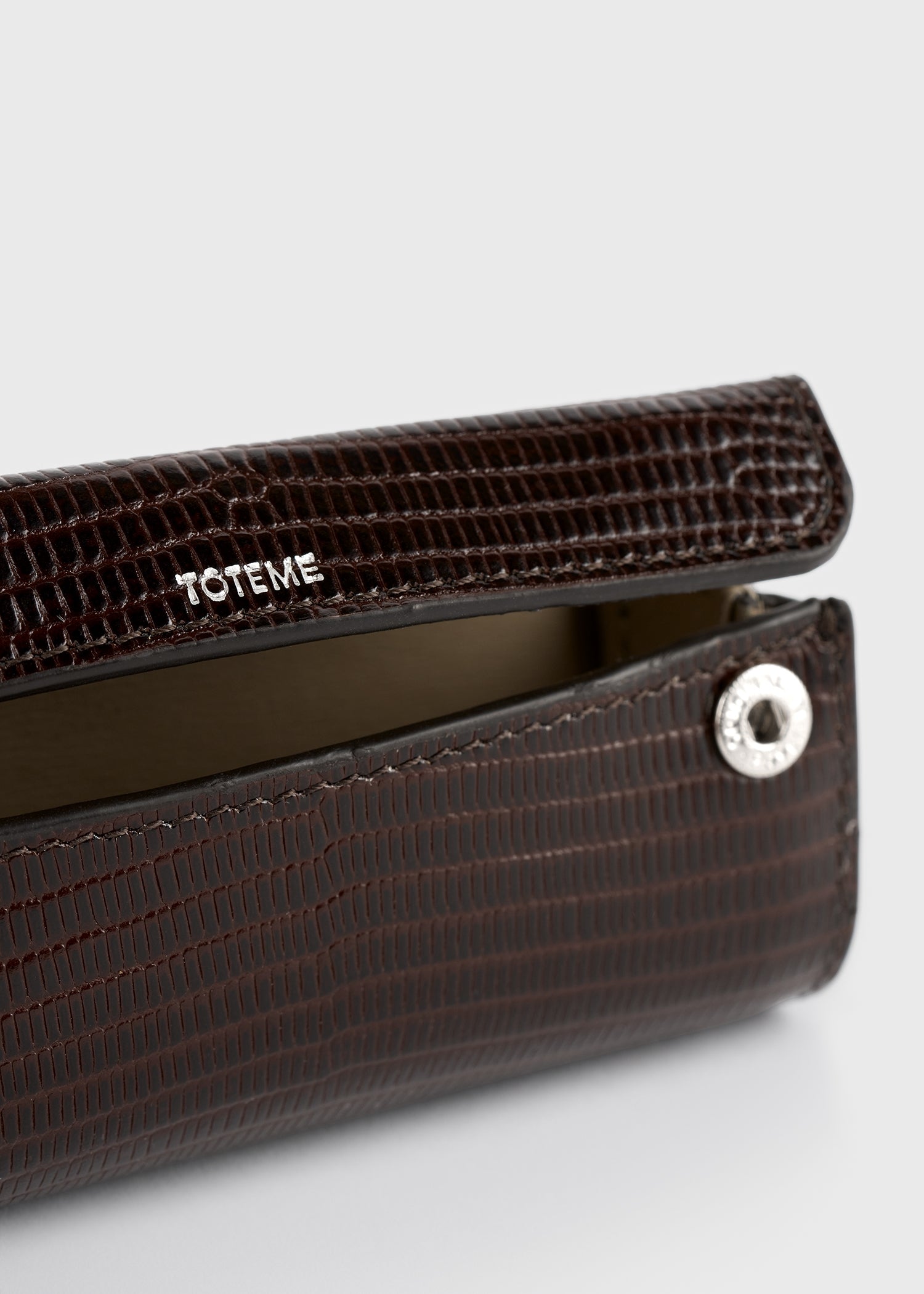 Lizard-embossed lipstick case brown