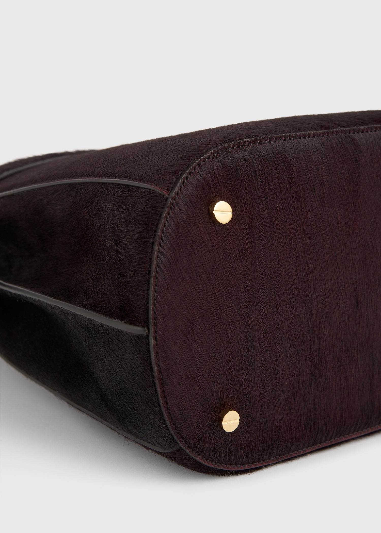 Belted pony hair bucket bag wine