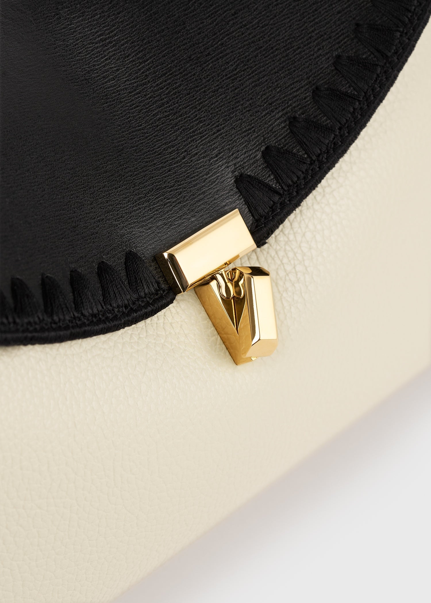 T-lock embroidered leather clutch black/milk