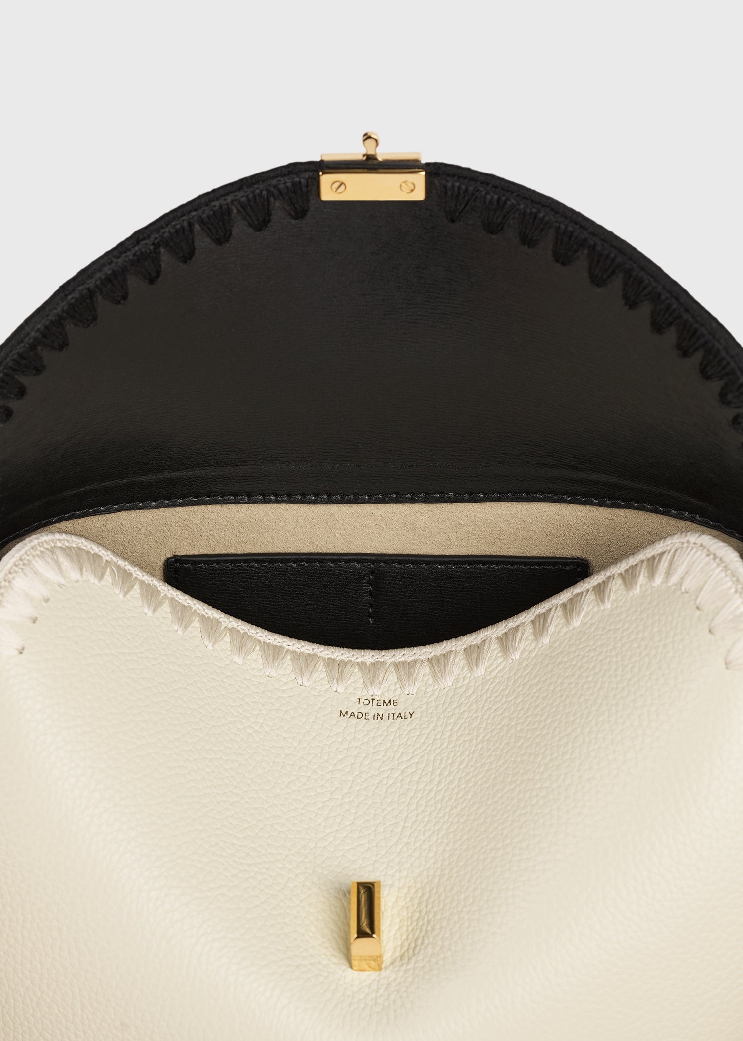 T-lock embroidered leather clutch black/milk